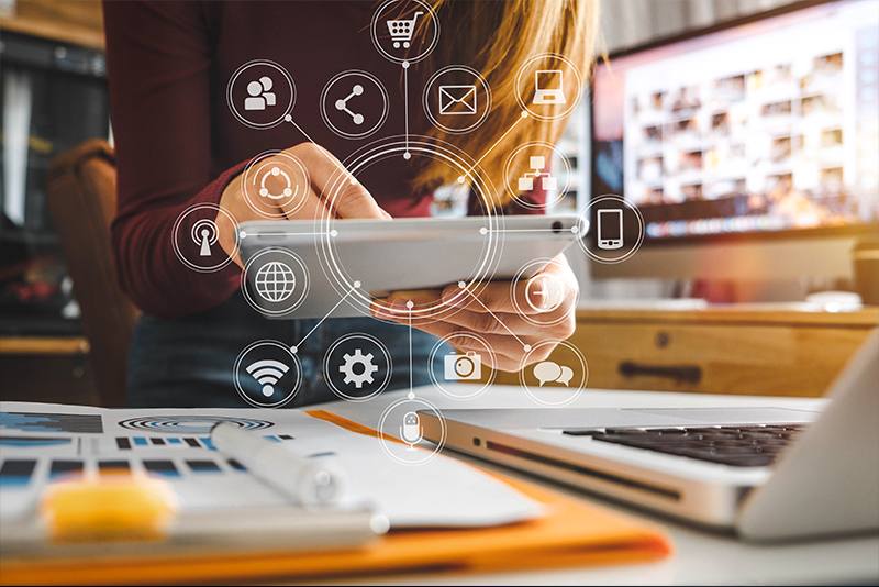 Person using a tablet surrounded by digital marketing icons